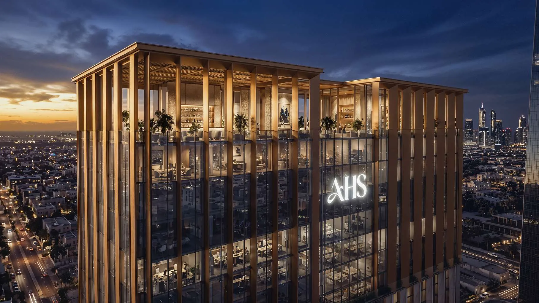 The glazed rooftop crown of AHS Twin Towers at night